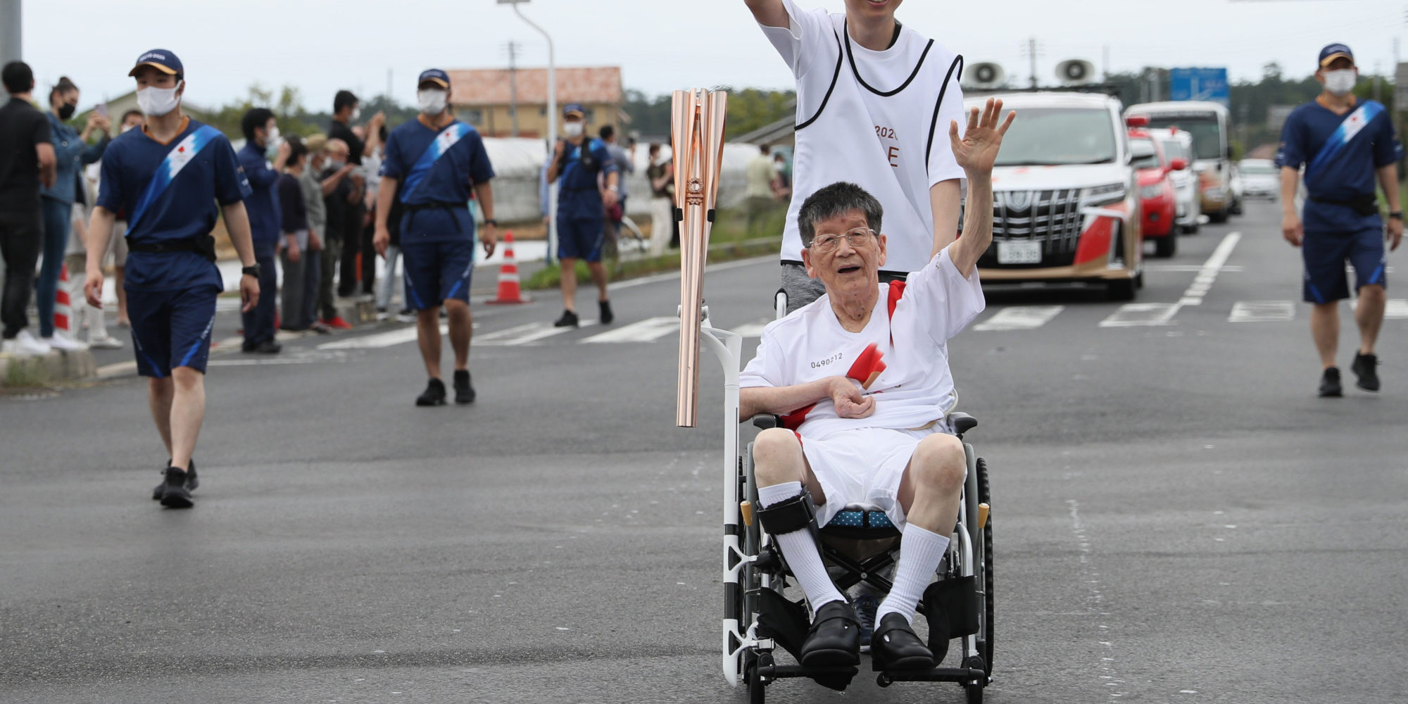TOKYO2020聖火リレーを車椅子で走る男性